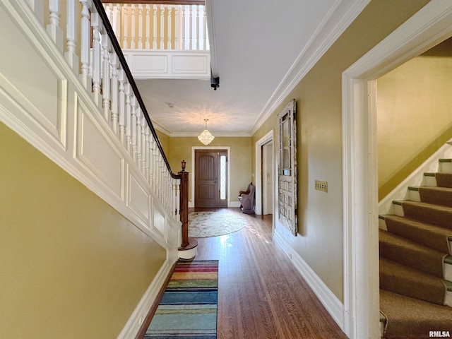 entrance foyer featuring ornamental molding and hardwood / wood-style floors