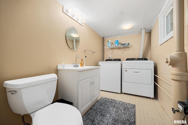 bathroom with toilet, vanity, and washer and clothes dryer