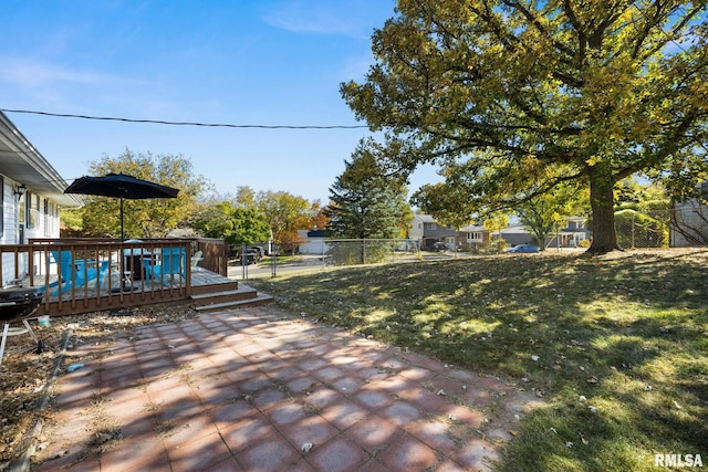 view of yard featuring a wooden deck and a patio