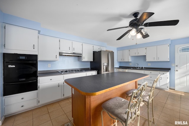 kitchen with white cabinets, stainless steel appliances, and light tile patterned floors