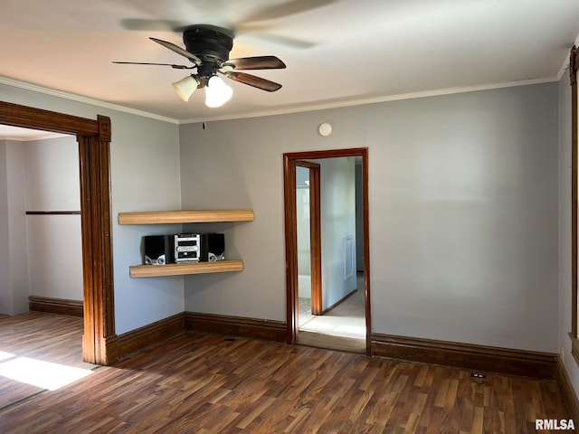 empty room featuring ornamental molding, dark wood-type flooring, and ceiling fan