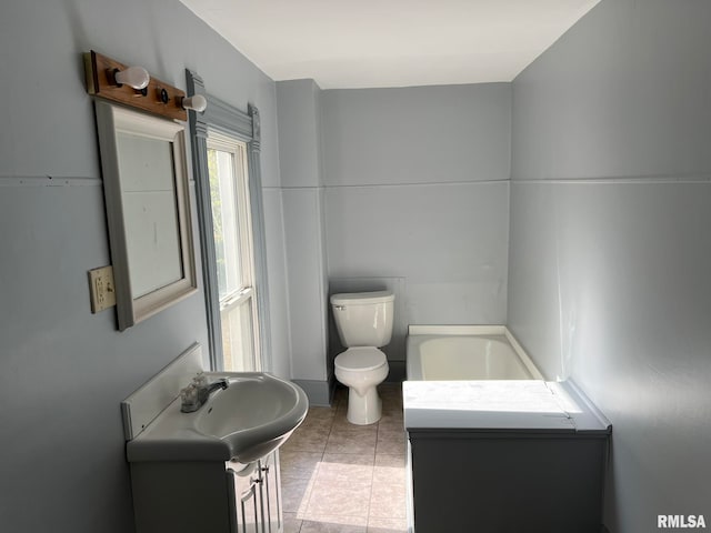 bathroom with vanity, a tub, toilet, and tile patterned flooring