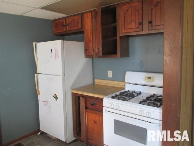 kitchen with a paneled ceiling and white appliances