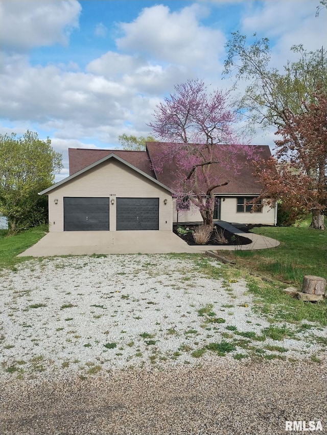 ranch-style home with a garage and gravel driveway