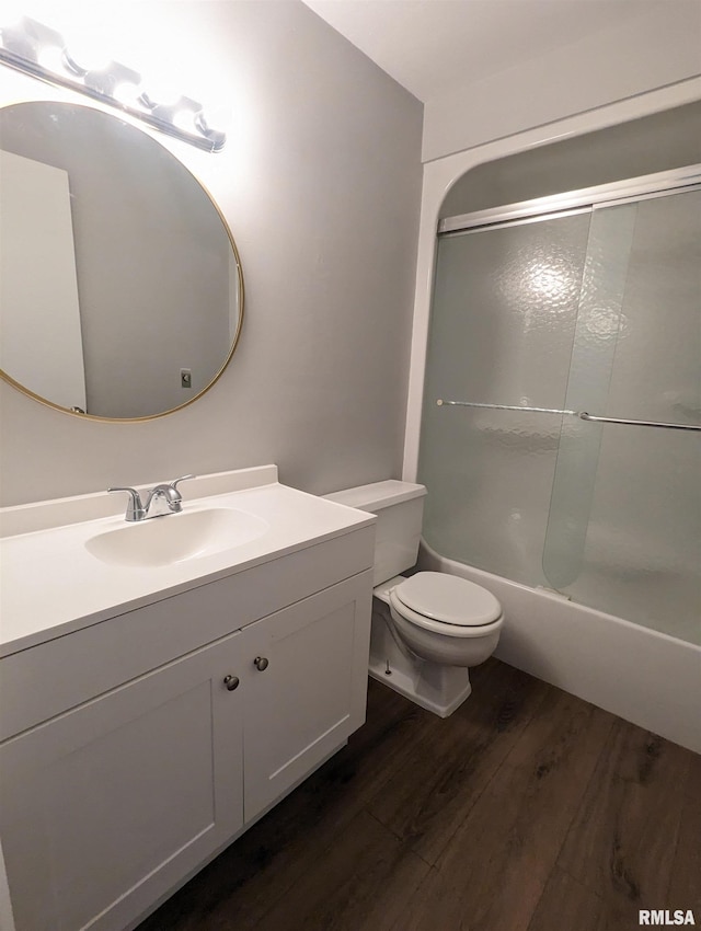 bathroom with toilet, tub / shower combination, wood finished floors, and vanity