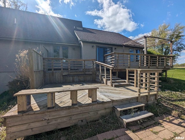 rear view of property featuring roof with shingles and a wooden deck