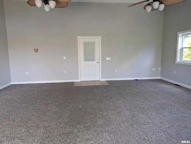 carpeted empty room featuring ceiling fan, visible vents, and baseboards