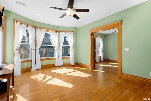 empty room with light wood-type flooring and ceiling fan