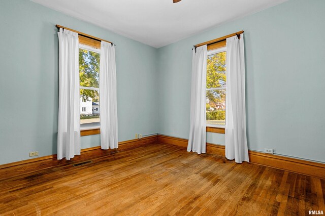 spare room featuring light hardwood / wood-style floors and a healthy amount of sunlight