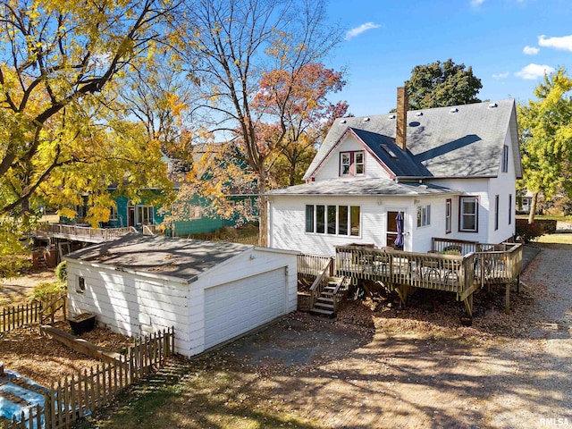 rear view of property with an outdoor structure and a deck