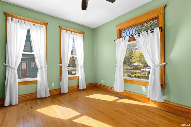 unfurnished room featuring light hardwood / wood-style flooring, a wealth of natural light, and ceiling fan