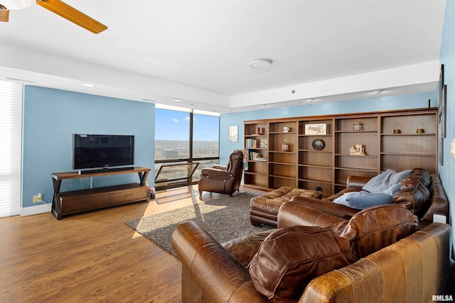 living room with light hardwood / wood-style flooring and ceiling fan