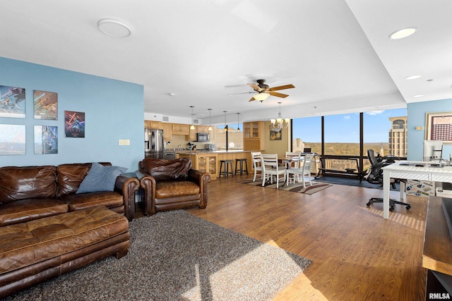 living room featuring a wall of windows, hardwood / wood-style flooring, and ceiling fan