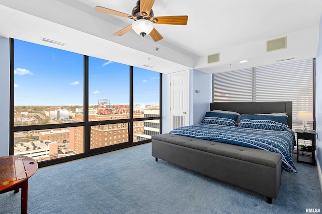 carpeted bedroom featuring a wall of windows and ceiling fan