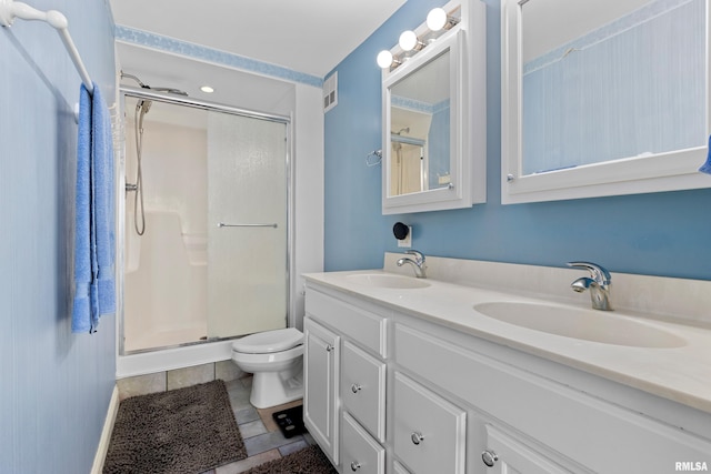 bathroom featuring vanity, toilet, tile patterned floors, and a shower with door