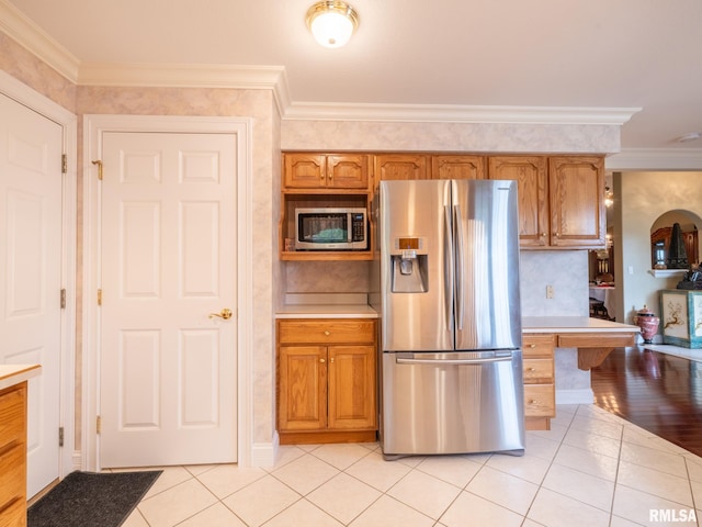 kitchen featuring crown molding, light hardwood / wood-style flooring, and appliances with stainless steel finishes