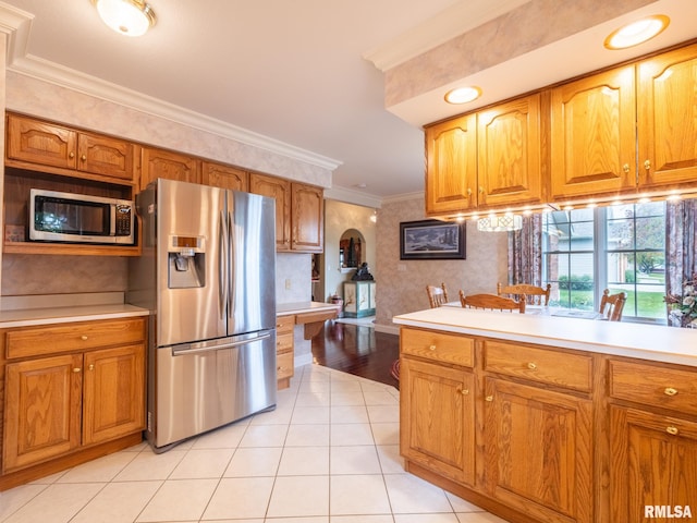 kitchen with light tile patterned floors, crown molding, and appliances with stainless steel finishes