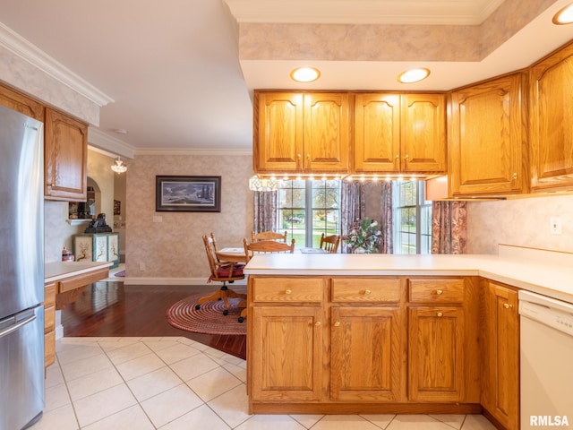 kitchen featuring white dishwasher, crown molding, light wood-type flooring, kitchen peninsula, and stainless steel refrigerator