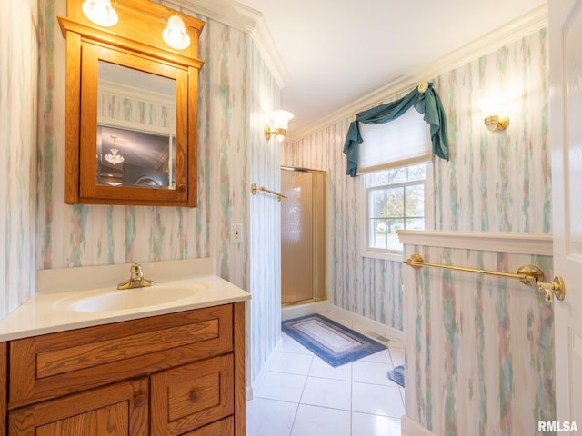 bathroom featuring tile patterned floors, vanity, a shower with shower door, and ornamental molding