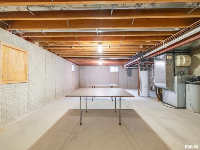 basement with heating unit, electric panel, brick wall, and water heater