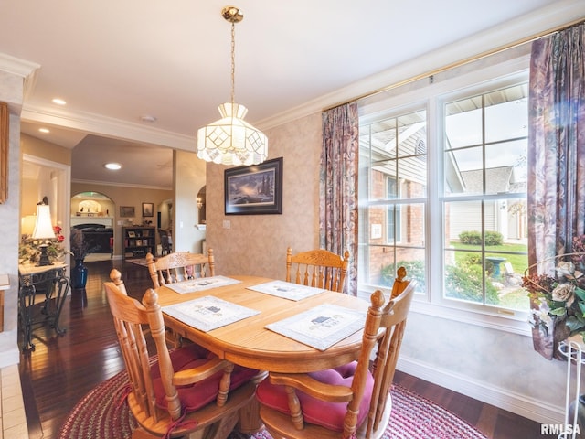 dining space with crown molding, a healthy amount of sunlight, and dark hardwood / wood-style floors