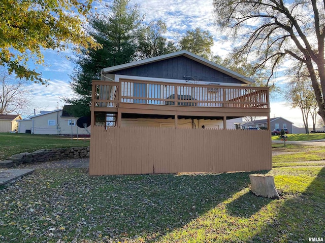 exterior space featuring a wooden deck and a lawn