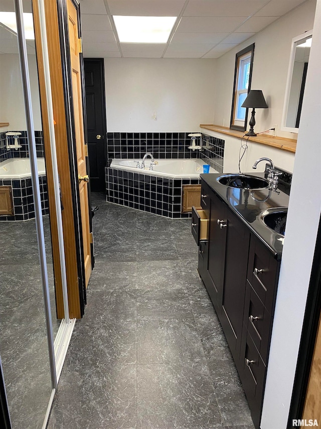 bathroom featuring a drop ceiling, separate shower and tub, and vanity