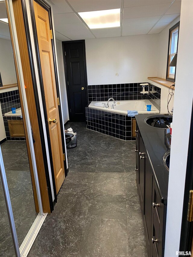 bathroom with a drop ceiling, independent shower and bath, and vanity