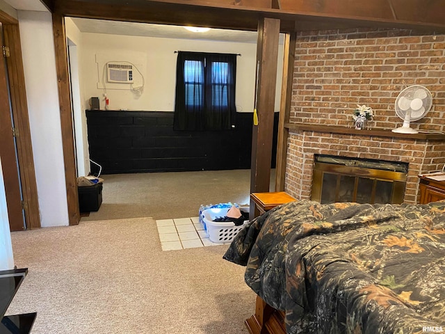 carpeted bedroom featuring a fireplace and a wall mounted AC