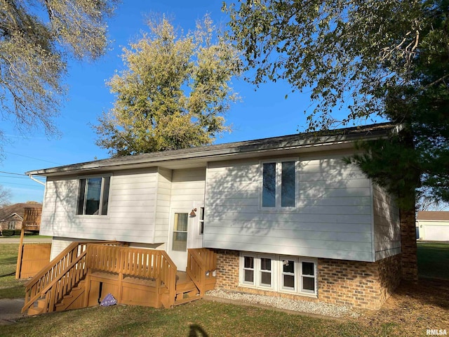 rear view of house featuring a deck and a lawn