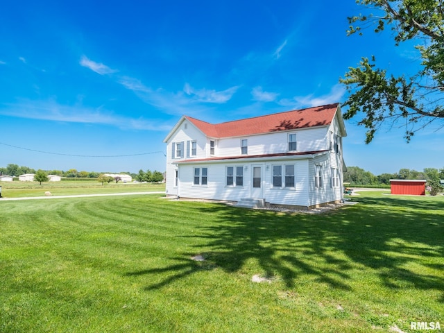 rear view of property featuring a lawn