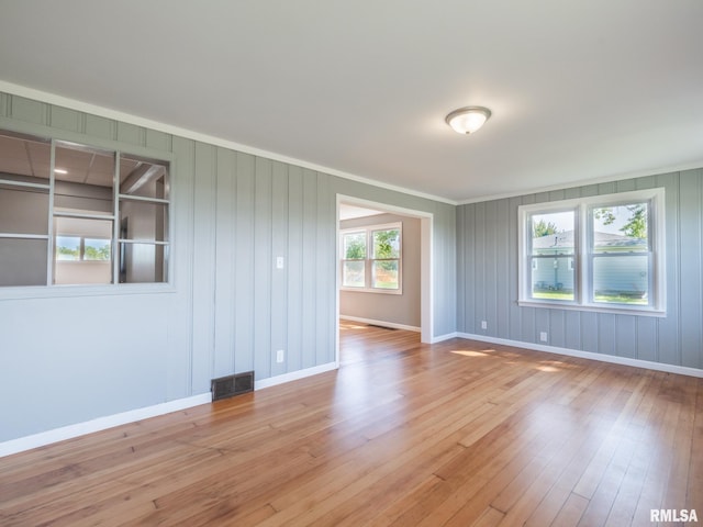 unfurnished room with crown molding and light hardwood / wood-style floors