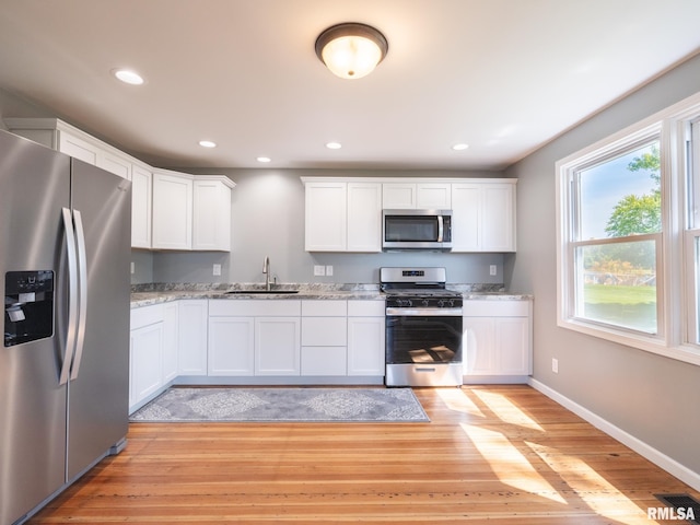 kitchen with sink, white cabinets, and appliances with stainless steel finishes