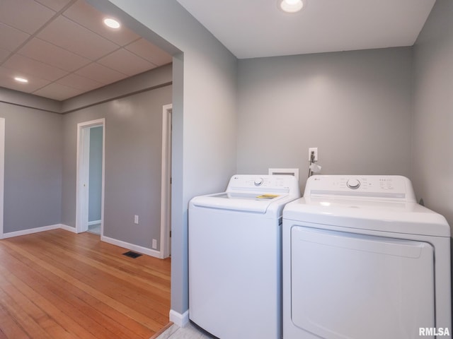 laundry area with light wood-type flooring and washer and clothes dryer