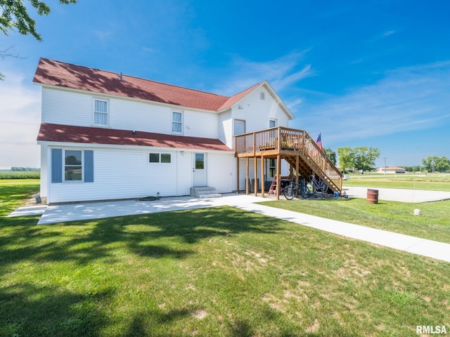 back of property with a wooden deck, a patio area, and a lawn