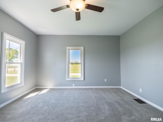 carpeted spare room with ceiling fan