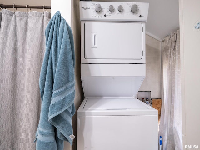 clothes washing area with stacked washing maching and dryer