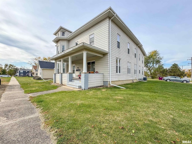 view of front of house featuring central AC, a porch, and a front lawn