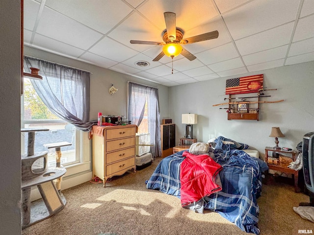 bedroom featuring a drop ceiling, carpet, and ceiling fan