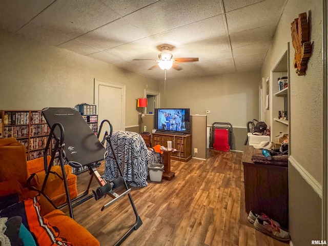 home office with dark wood-type flooring, a paneled ceiling, and ceiling fan