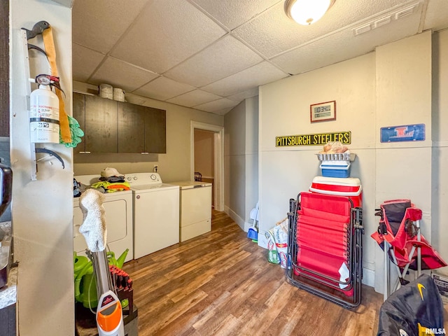 washroom with hardwood / wood-style floors, washer and dryer, and cabinets