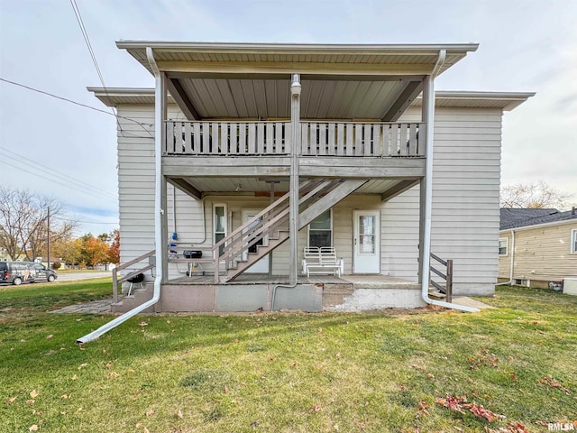 back of house with a yard and a balcony