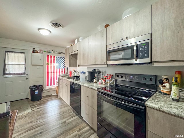 kitchen featuring light hardwood / wood-style floors, black appliances, sink, and light brown cabinets