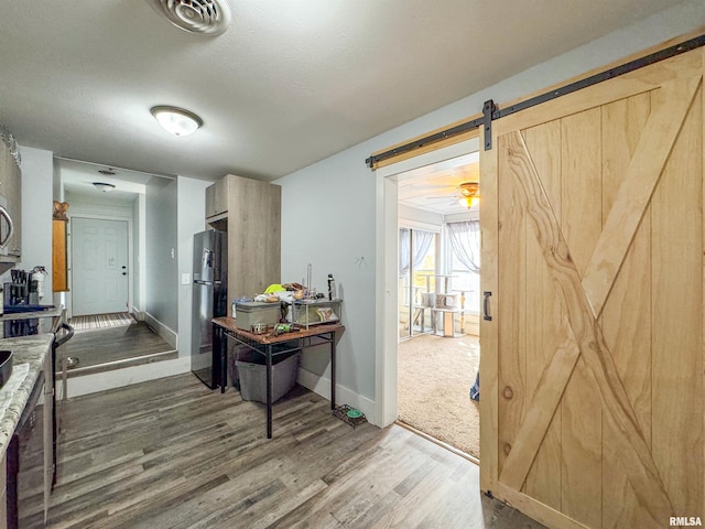 corridor featuring a barn door and hardwood / wood-style floors