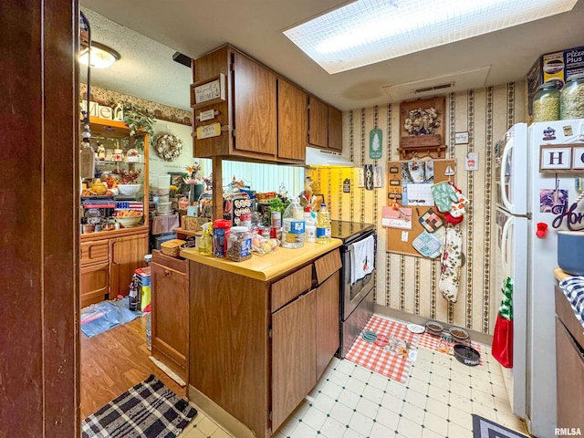 kitchen featuring white refrigerator and stainless steel electric range oven