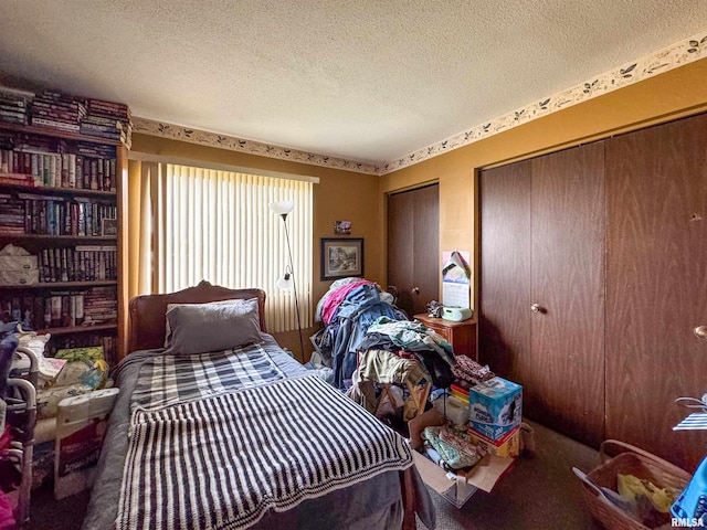 carpeted bedroom featuring multiple closets and a textured ceiling