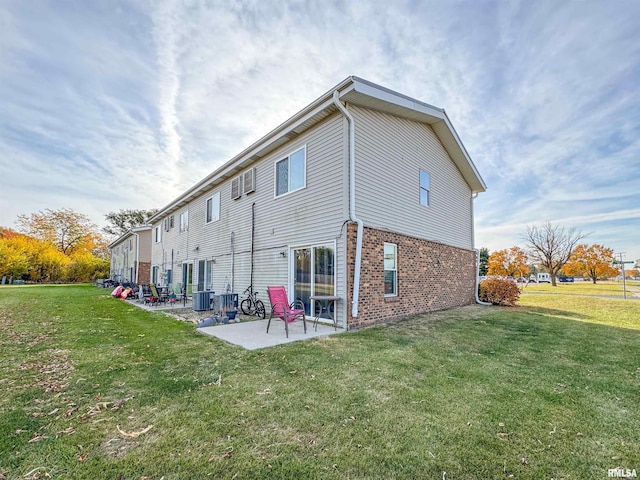 back of house with a patio area and a lawn