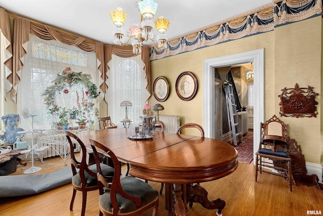 dining space with an inviting chandelier and hardwood / wood-style flooring