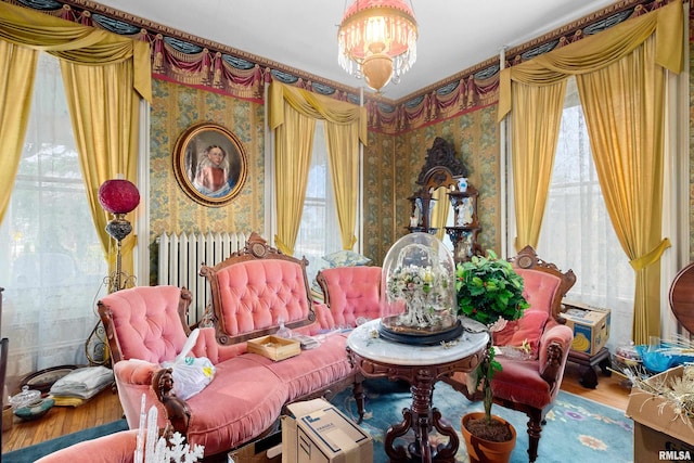 living area featuring radiator heating unit, a notable chandelier, and hardwood / wood-style floors