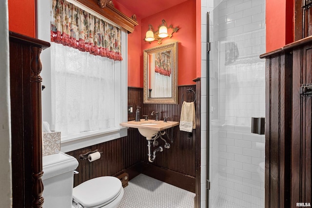 bathroom with tile patterned flooring, toilet, and a shower with door